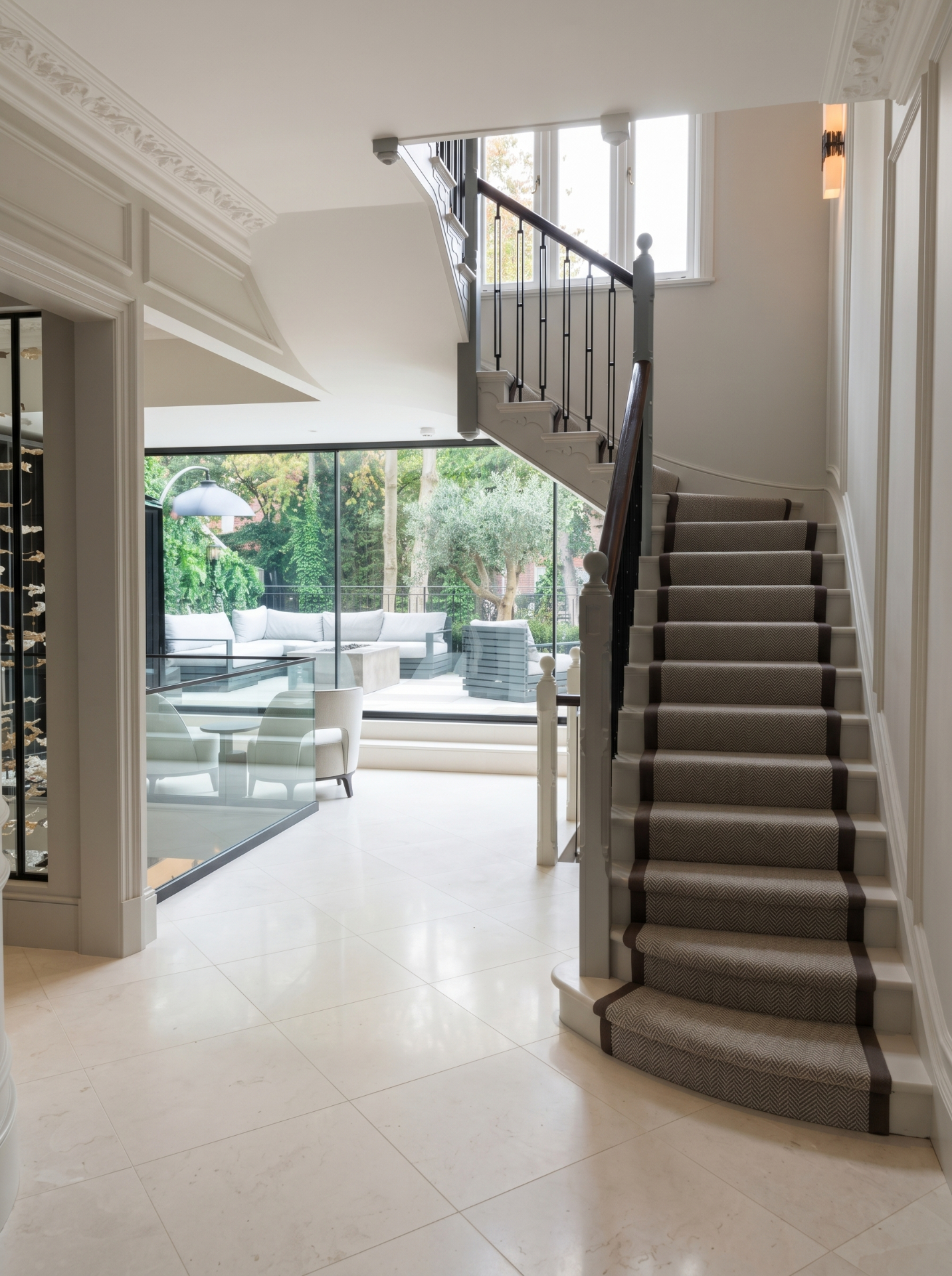 Traditional staircase with fitted runner in a bright hallway